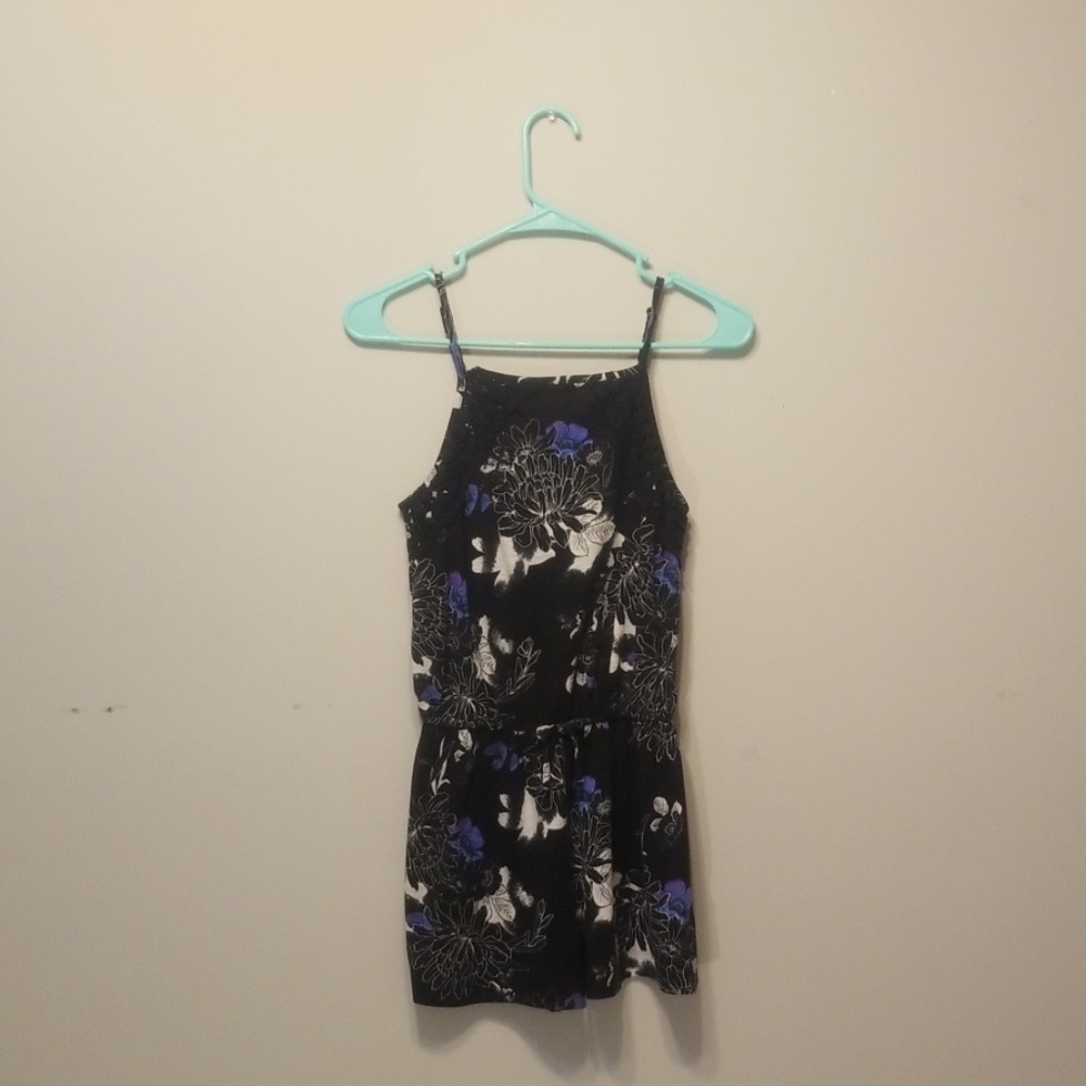 A black romper with purple and white floral print